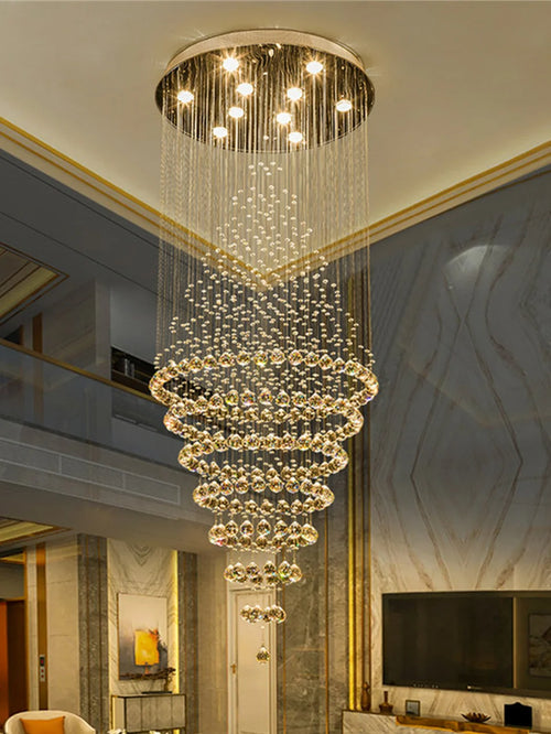 Lustre cascade en cristal suspendu dans une cage d'escalier en double hauteur