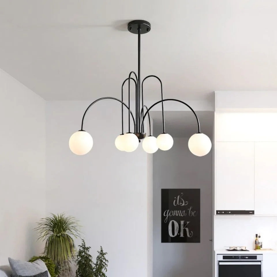 Arcadie Lustre à Bras en Arc – version noire dans une pièce blanche