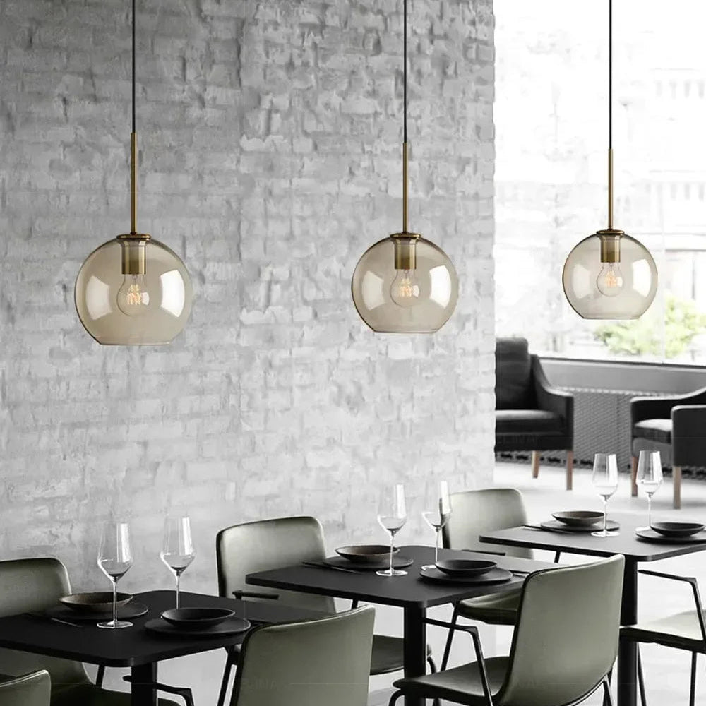 Ambra Suspension en Verre Ambré, 5 Formes au Choix – suspensions devant un mur de briques blanches