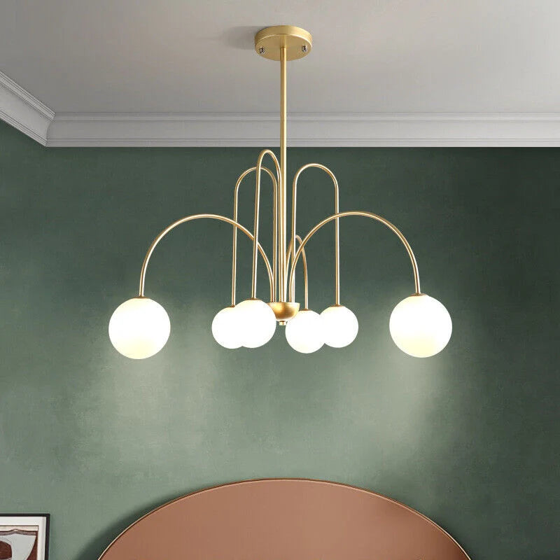 Arcadie Lustre à Bras en Arc – version dorée devant un mur vert foncé