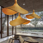 Hatira Suspension Chapeau en Bambou Tressé – plusieurs abat-jours devant de grandes baies donnant sur un jardin