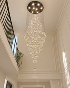 Vue de dessous du lustre cascade en cristal dans la cage d'escalier