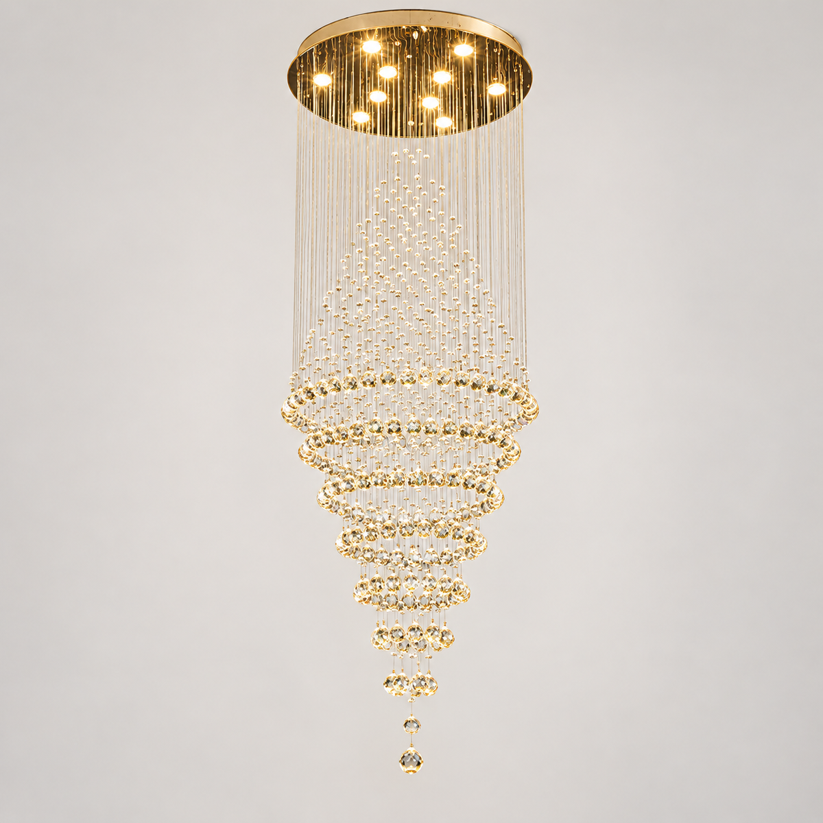 Lustre cascade en cristal finition or, colonne pour escalier, sur fond clair