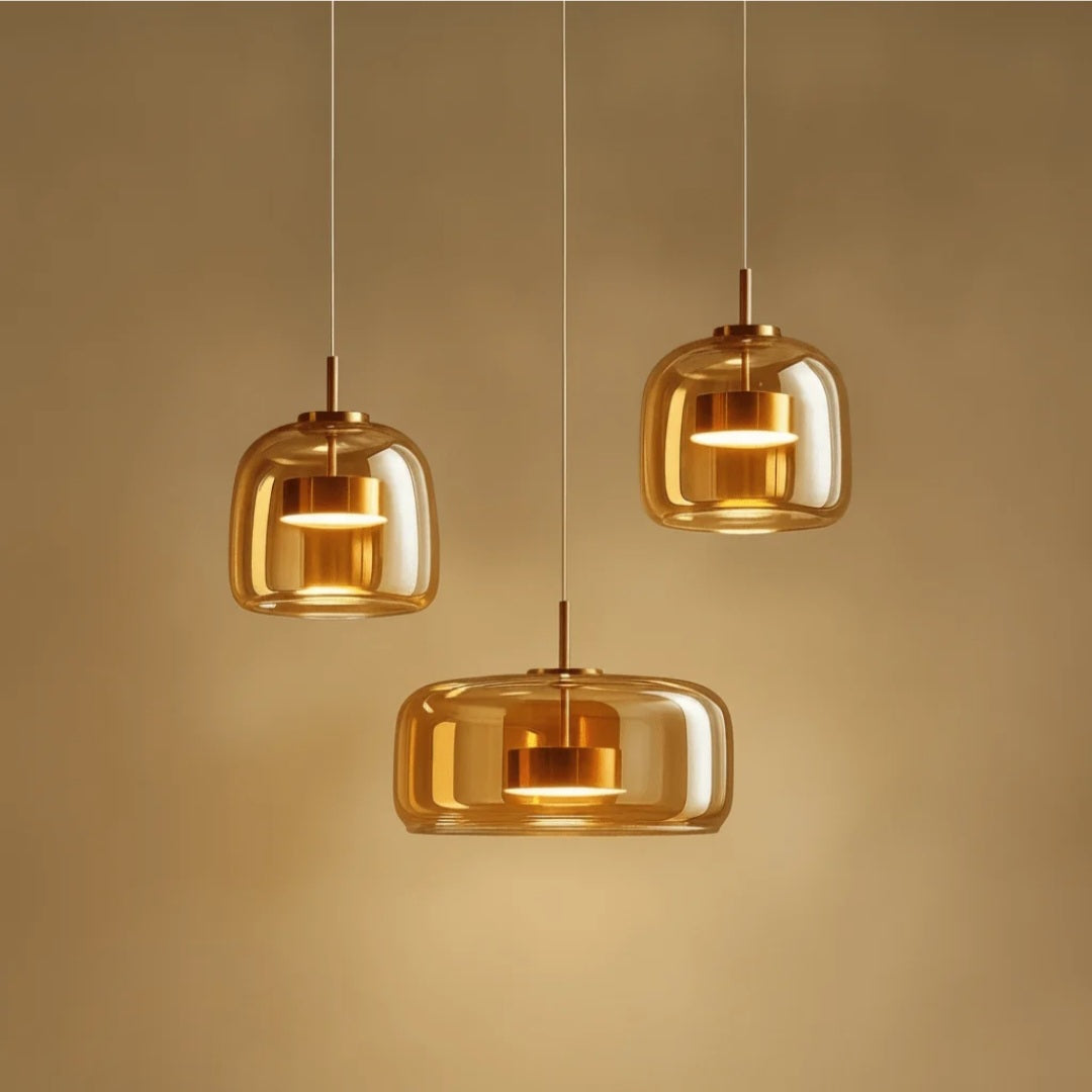 Trilia Suspension Trio en Verre, Ambré ou Fumé, sur Platine Ronde – gros plan des suspensions en verre ambré, lumière chaude