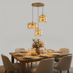 Trilia Suspension Trio en Verre, Ambré ou Fumé, sur Platine Ronde – suspensions en verre ambré au-dessus d'une table à manger dressée