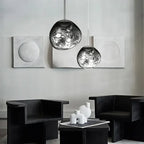 Lavane Suspension Globe en Verre Fondu Irrégulier – globes gris dans une pièce avec fauteuils noirs