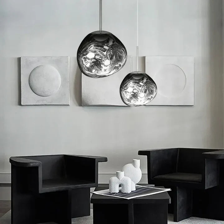 Lavane Suspension Globe en Verre Fondu Irrégulier – globes gris dans une pièce avec fauteuils noirs