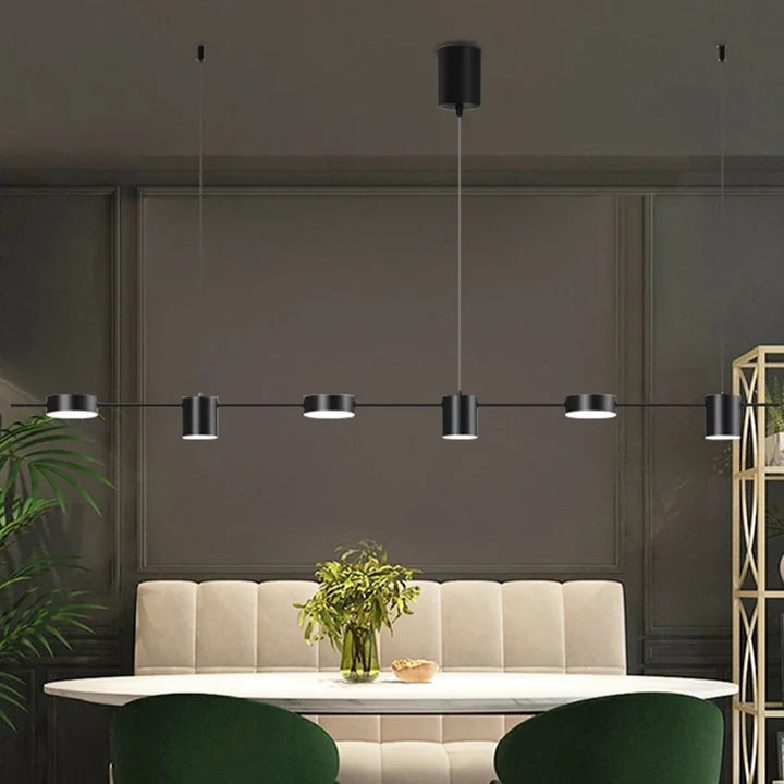 Tubo Suspension Linéaire à Spots – version noire dans un salon sombre avec canapé