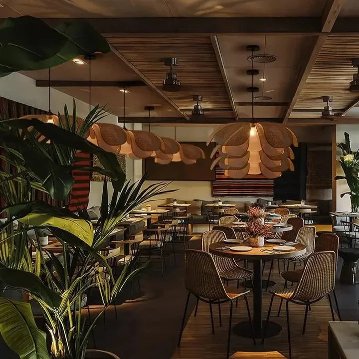 Lotus Suspension en Rotin Tressé – plusieurs abat-jours dans un restaurant avec plantes